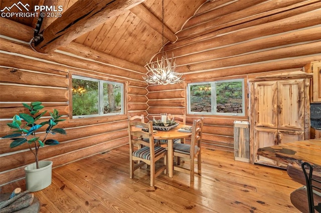 dining space featuring rustic walls, vaulted ceiling with beams, wood ceiling, an inviting chandelier, and light hardwood / wood-style flooring