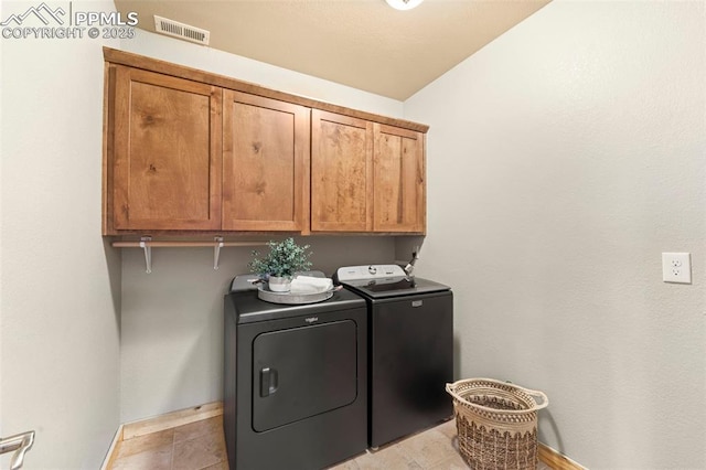 clothes washing area featuring cabinets, light tile patterned floors, and independent washer and dryer