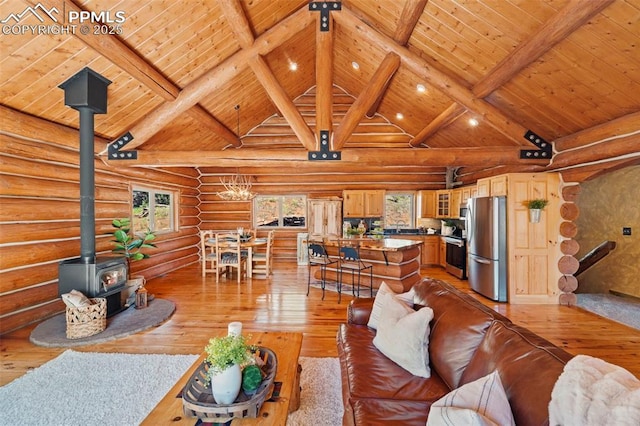 living room with light hardwood / wood-style flooring, log walls, beam ceiling, and a wood stove