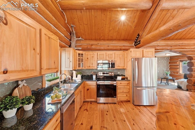 kitchen featuring tasteful backsplash, sink, rustic walls, stainless steel appliances, and light brown cabinets