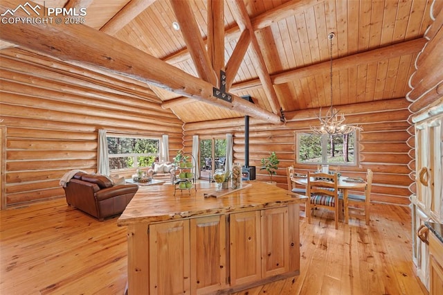 kitchen featuring hanging light fixtures, wooden counters, beamed ceiling, and a center island