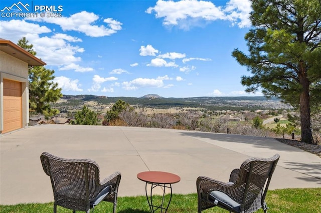 view of patio featuring a garage and a mountain view