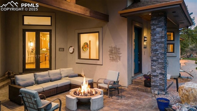 view of patio / terrace with french doors and an outdoor living space with a fire pit