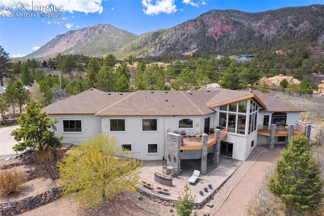 back of property with a patio area and a deck with mountain view