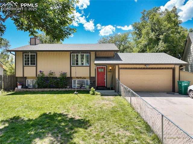 raised ranch featuring a garage and a front yard