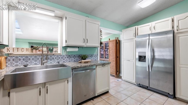 kitchen featuring sink, stainless steel appliances, white cabinets, and stone counters