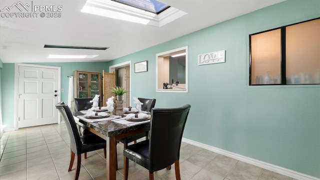 dining space with light tile patterned flooring and a skylight