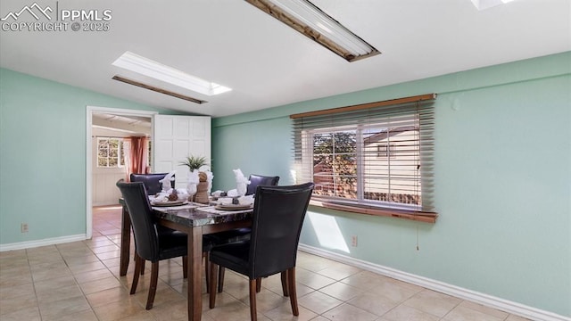 dining space with light tile patterned floors and vaulted ceiling