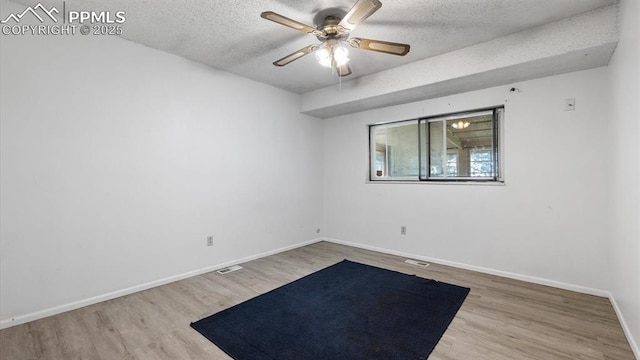 unfurnished room featuring ceiling fan, hardwood / wood-style flooring, and a textured ceiling