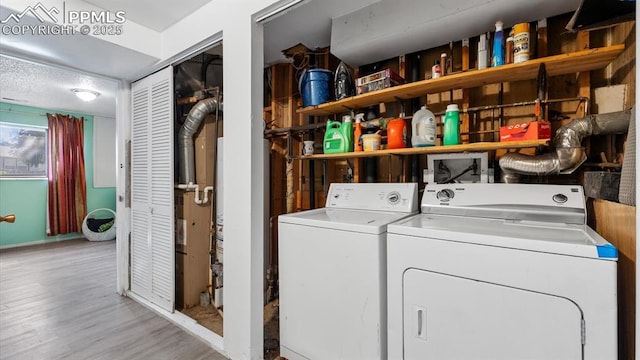 washroom with light hardwood / wood-style floors and washer and dryer