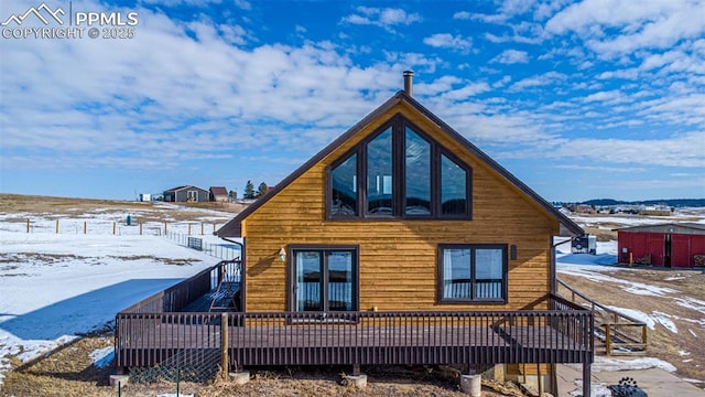 snow covered house with a wooden deck