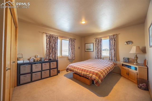 carpeted bedroom featuring multiple windows and a textured ceiling