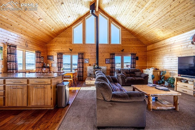 living room featuring wood walls, wooden ceiling, high vaulted ceiling, and a wood stove