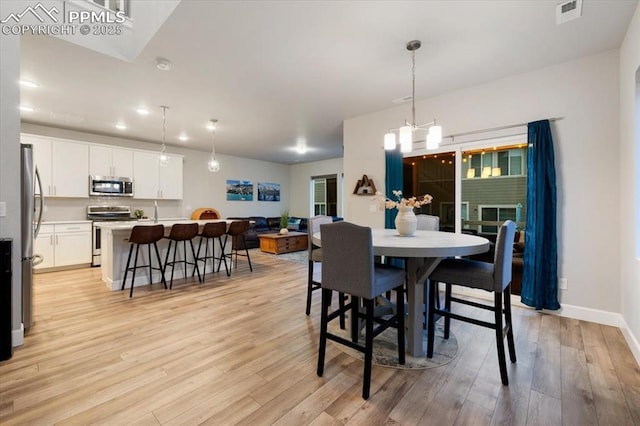 dining room featuring light hardwood / wood-style flooring and a chandelier