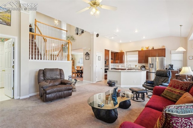 carpeted living room with sink, a towering ceiling, and ceiling fan