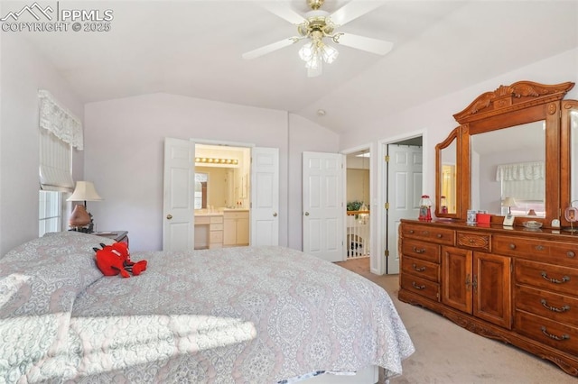 carpeted bedroom with vaulted ceiling, connected bathroom, and ceiling fan