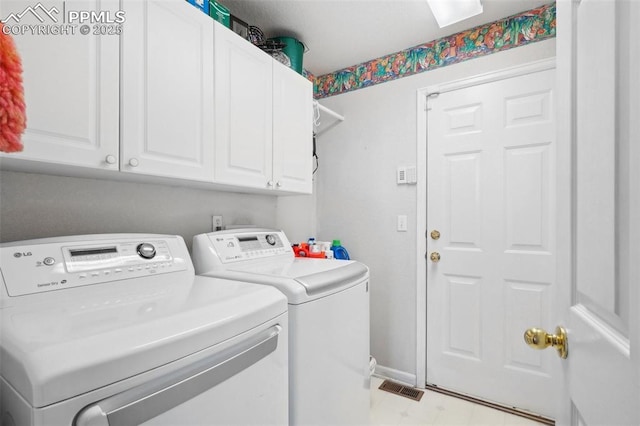 laundry room featuring washing machine and dryer and cabinets