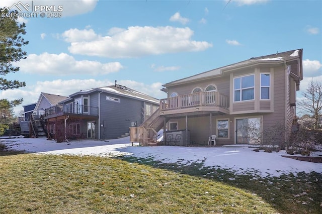 rear view of property featuring a balcony and a lawn