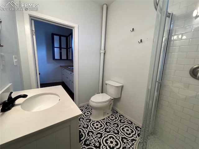 bathroom with vanity, tile patterned flooring, toilet, and walk in shower