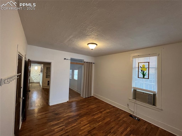 spare room with cooling unit, dark hardwood / wood-style floors, and a textured ceiling