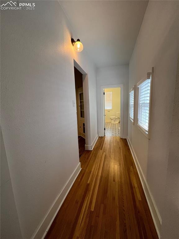 corridor with hardwood / wood-style flooring