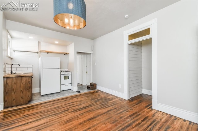 kitchen with white appliances, dark hardwood / wood-style flooring, and sink