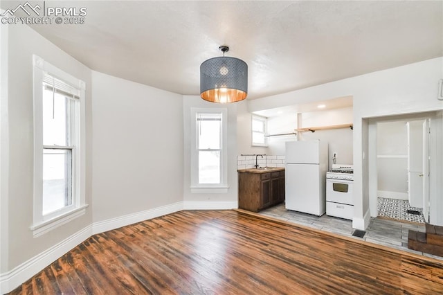 kitchen with white appliances, plenty of natural light, sink, and light hardwood / wood-style flooring