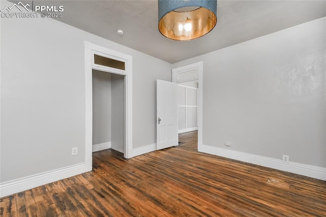 unfurnished bedroom featuring dark hardwood / wood-style floors and a closet