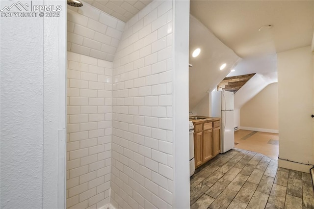 bathroom featuring vanity, vaulted ceiling, and walk in shower