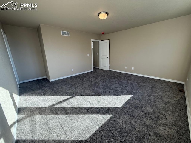 empty room featuring dark colored carpet