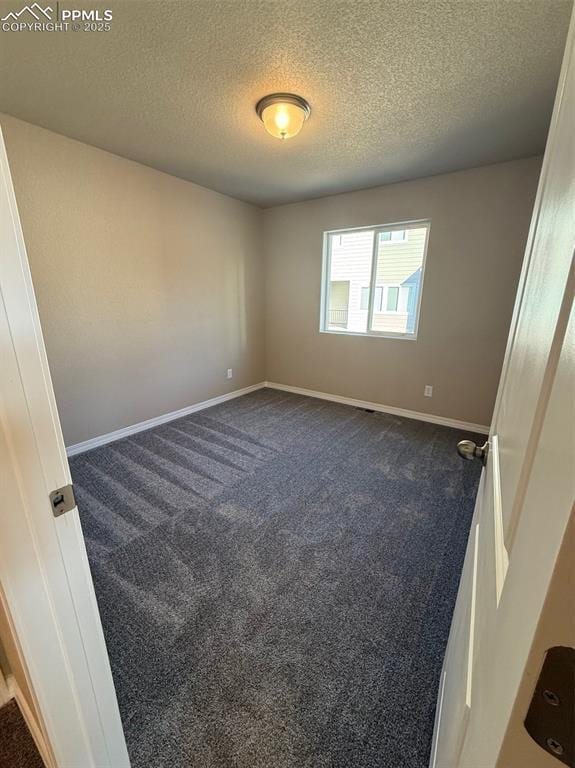 carpeted spare room with a textured ceiling