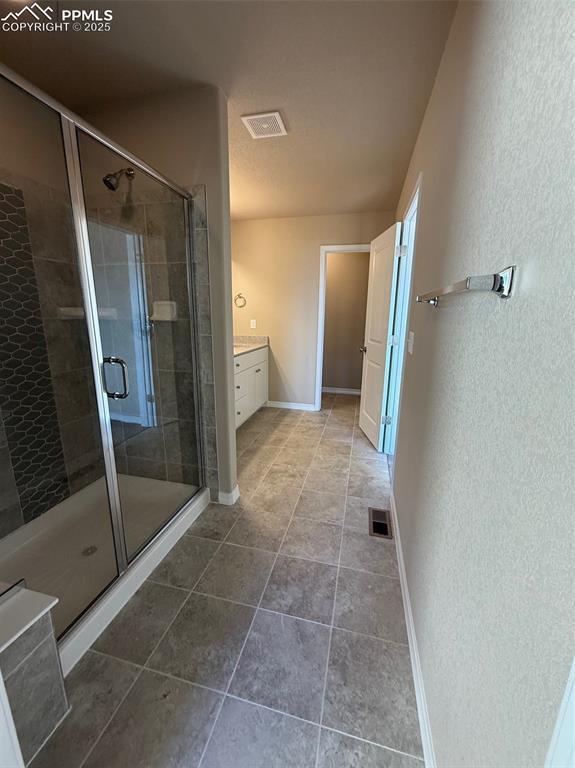 bathroom with vanity and a shower with door