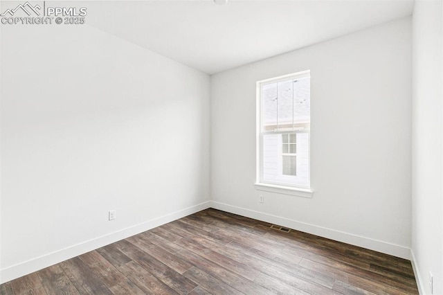 spare room featuring dark wood-type flooring