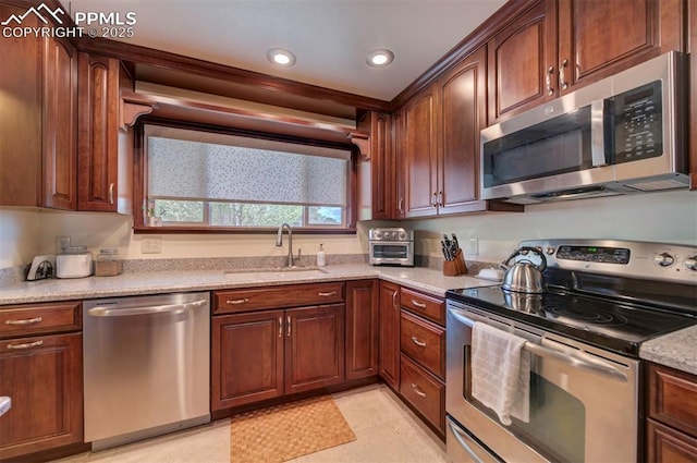 kitchen featuring light stone counters, sink, stainless steel appliances, and light tile patterned flooring