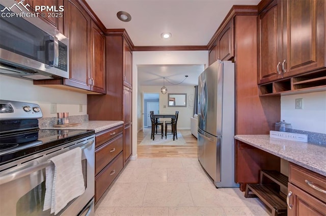 kitchen featuring ornamental molding, appliances with stainless steel finishes, light stone countertops, and light tile patterned floors