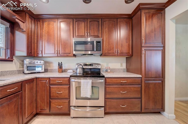 kitchen featuring light stone countertops and stainless steel appliances