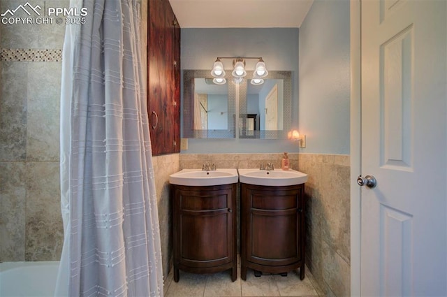 bathroom featuring vanity, tile walls, tile patterned floors, and shower / bath combo with shower curtain