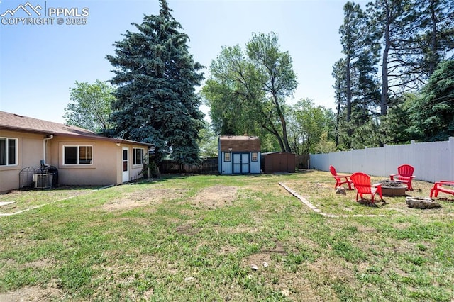 view of yard with central AC, a shed, and a fire pit