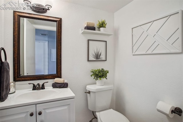 bathroom featuring vanity and toilet