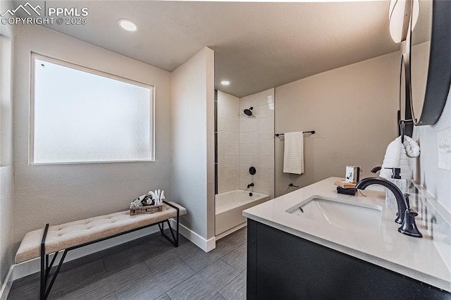 bathroom featuring tiled shower / bath and vanity