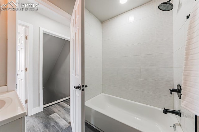 bathroom with vanity, hardwood / wood-style floors, and tiled shower / bath