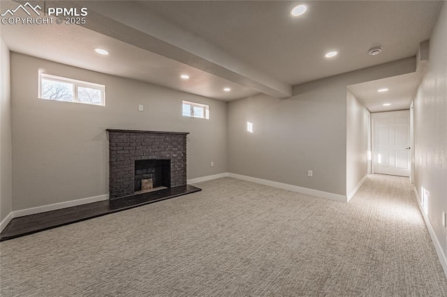 unfurnished living room with beamed ceiling, plenty of natural light, carpet flooring, and a brick fireplace