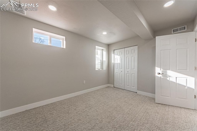 unfurnished bedroom with multiple windows, light colored carpet, and a closet