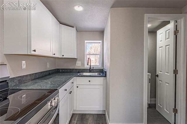 kitchen featuring white cabinetry, stainless steel electric range oven, sink, and a textured ceiling