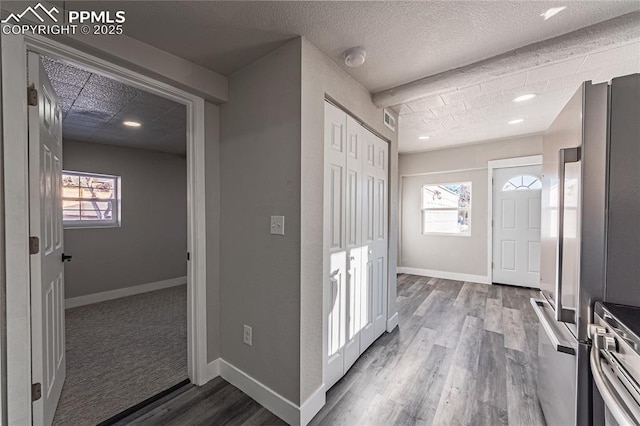 foyer with wood-type flooring, a wealth of natural light, and a textured ceiling