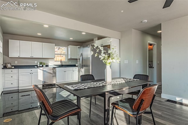 dining area featuring ceiling fan, dark hardwood / wood-style floors, and sink