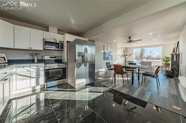 kitchen with ceiling fan, stainless steel appliances, and white cabinets