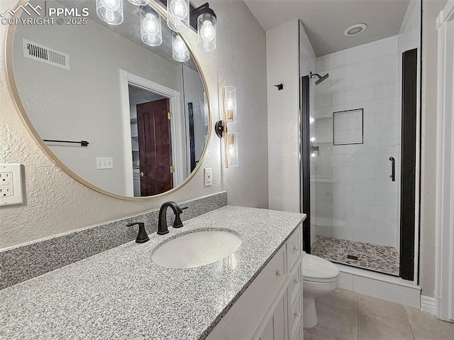 bathroom with tiled shower, vanity, toilet, and tile patterned floors