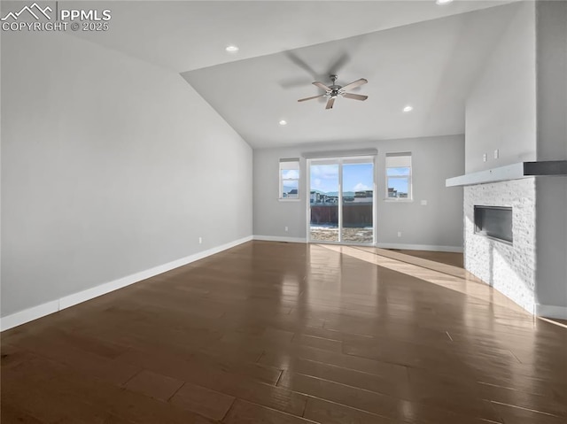 unfurnished living room featuring lofted ceiling, a fireplace, dark hardwood / wood-style floors, and ceiling fan