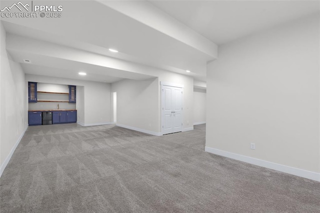 basement featuring light carpet and bar area